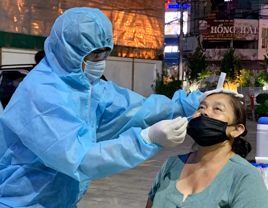  Cán bộ y tế lấy mẫu xét nghiệm sàng lọc SARS-CoV-2 tại chợ đêm, TP. Pleiku. Ảnh: Như Nguyện