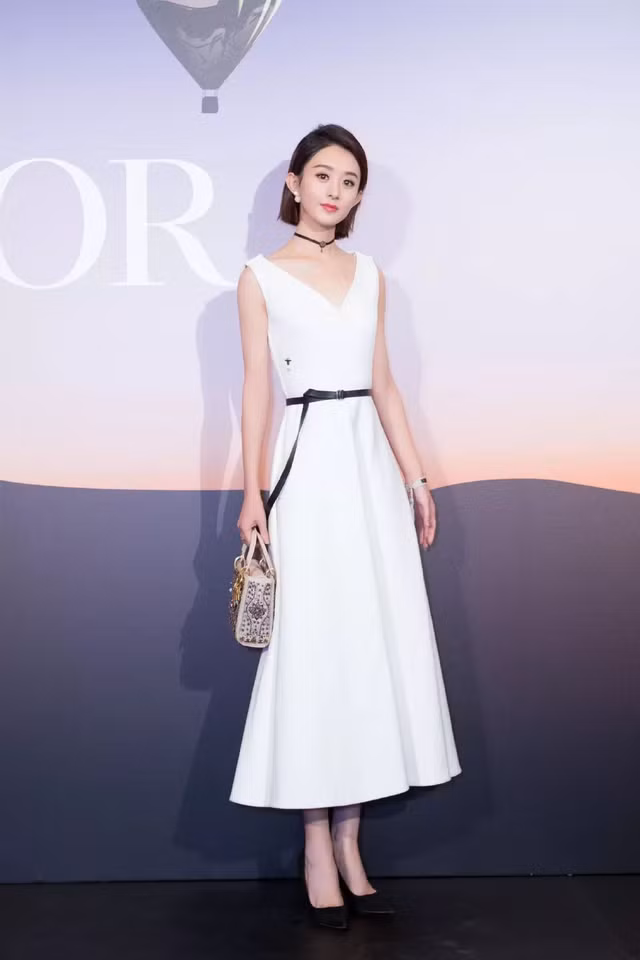 Triệu Lệ Dĩnh sang trọng, thanh lịch với váy trắng dáng xòe tạo điểm nhấn quanh eo bằng dây thắt lưng giúp cô nàng khoe vòng eo con kiến mà vẫn quyến rũ gợi cảm.