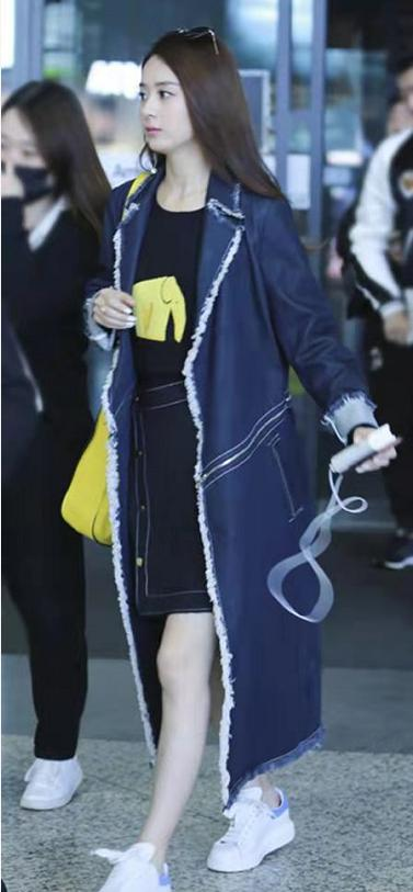 Cô khéo kết hợp áo khoác denim màu xanh đậm bên ngoài, kiểu áo khoác dài quá đầu gối trông rất phong cách với thiết kế những đường viền bo cong quanh áo màu trắng mang đậm phong cách thời trang đường phố.