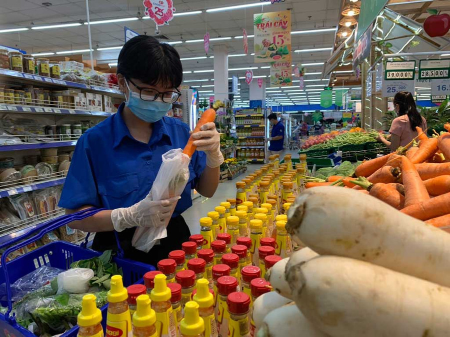 Nhóm đi chợ giúp người dân trong khu phong tỏa mua các mặt hàng thiết yếu như rau củ, thịt, cá... ẢNH: DUY HIỆP