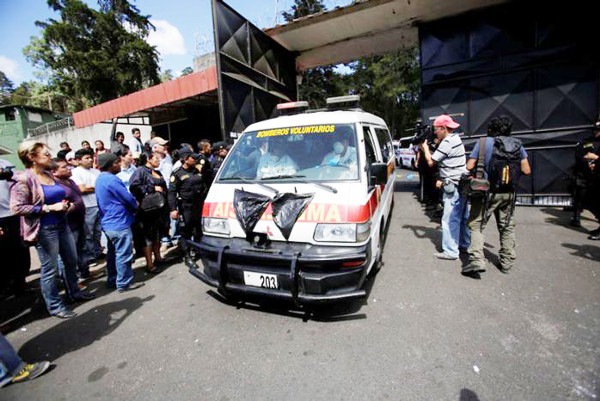 Xe cứu hỏa chuyển thi thể các em ra khỏi trung tâm. Ảnh: Reuters