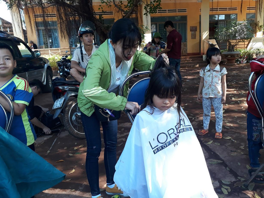 Cắt tóc cho trẻ em vùng biên giới. Ảnh: N.T Cắt tóc cho trẻ em vùng biên giới. Ảnh: N.T