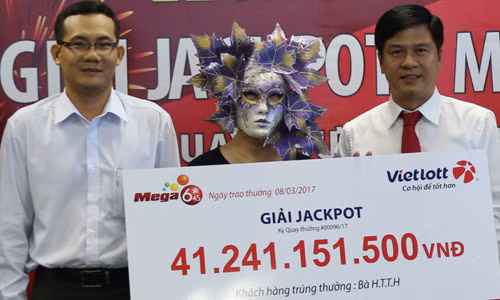 Nữ khách hàng nhận giải từ đại diện Vietlott và đại diện các bên liên quan, người chứng kiến...