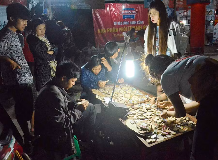  Khắc chữ lên móc chìa khóa bằng gỗ tạo sự thích thú cho du khách. Ảnh: P.L