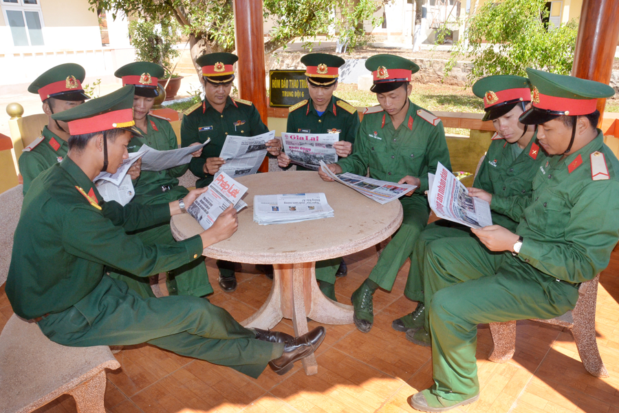 Cán bộ, chiến sĩ đọc báo trong giờ giải lao. Ảnh: V.H