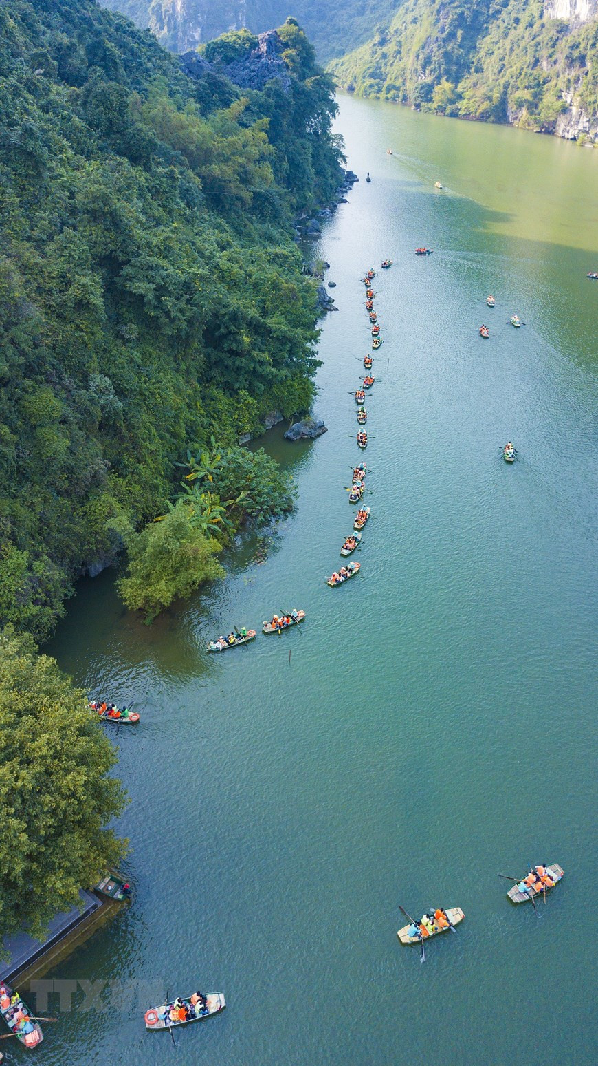 Một trong những trải nghiệm thú vị dành cho du khách khi đến Tràng An chính là ngồi thuyền xuôi dọc theo dòng sông nhìn ngắm cảnh vật xung quanh. (Ảnh: Minh Đức/TTXVN)
