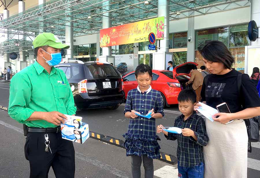  Nhân viên Công ty Mai Linh Gia Lai tặng khẩu trang y tế cho 3 mẹ con chị Phượng tại Cảng Hàng không Pleiku. Ảnh: L.H