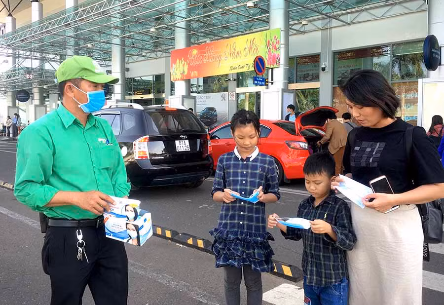  Nhân viên Công ty Mai Linh Gia Lai tặng khẩu trang y tế cho 3 mẹ con chị Phượng tại Cảng Hàng không Pleiku. Ảnh: L.H