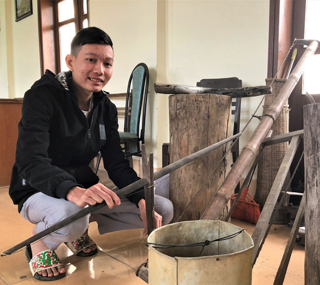 Việt Anh bên những hiện vật dân gian quý hiếm do cậu sưu tầm tặng nhà truyền thống huyện