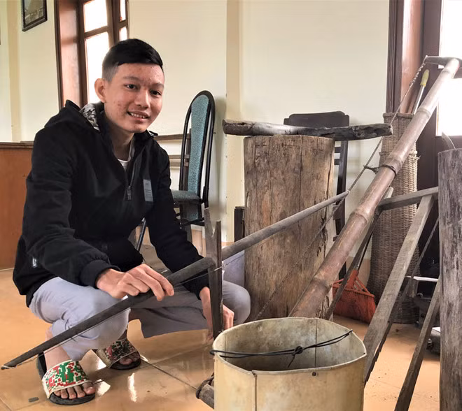 Việt Anh bên những hiện vật dân gian quý hiếm do cậu sưu tầm tặng nhà truyền thống huyện