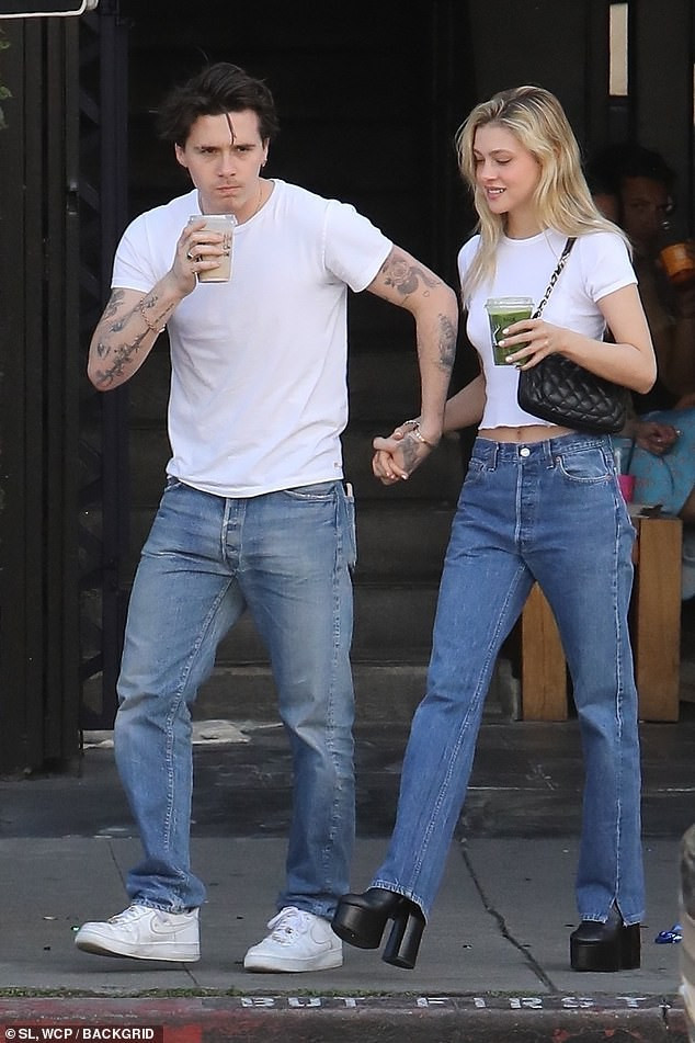 Cả hai mặc đồ đôi giản dị với áo phông trắng và quần jeans năng động, cá tính.