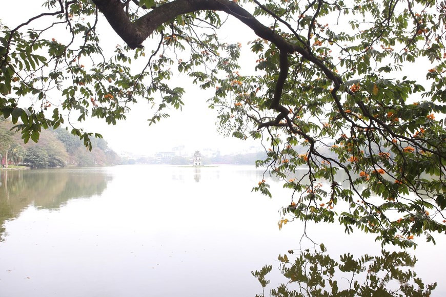 Đây là những ngày đẹp nhất trong năm khi những hàng cây thân quen bên hồ lá chuyển sắc vàng, đỏ, nhẹ rơi để lại những cành khẳng khiu đẹp như tranh vẽ soi bóng mặt gương. (Ảnh: Anh Tuấn/TTXVN)