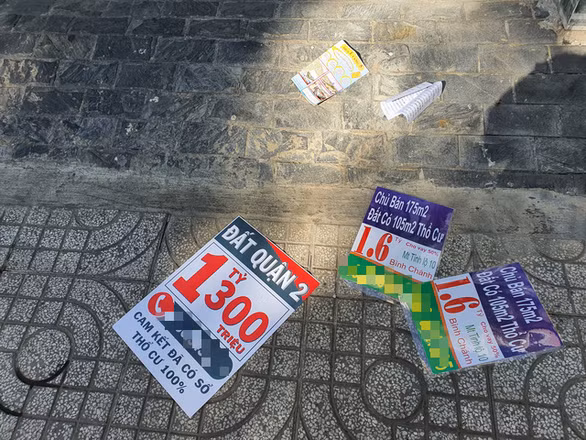 Chỉ qua đêm, các tờ quảng cáo nhà đất đã rải đầy trước cửa nhà dân ở khu Tân Tạo, Bình Tân - Ảnh: MẠNH DŨNG