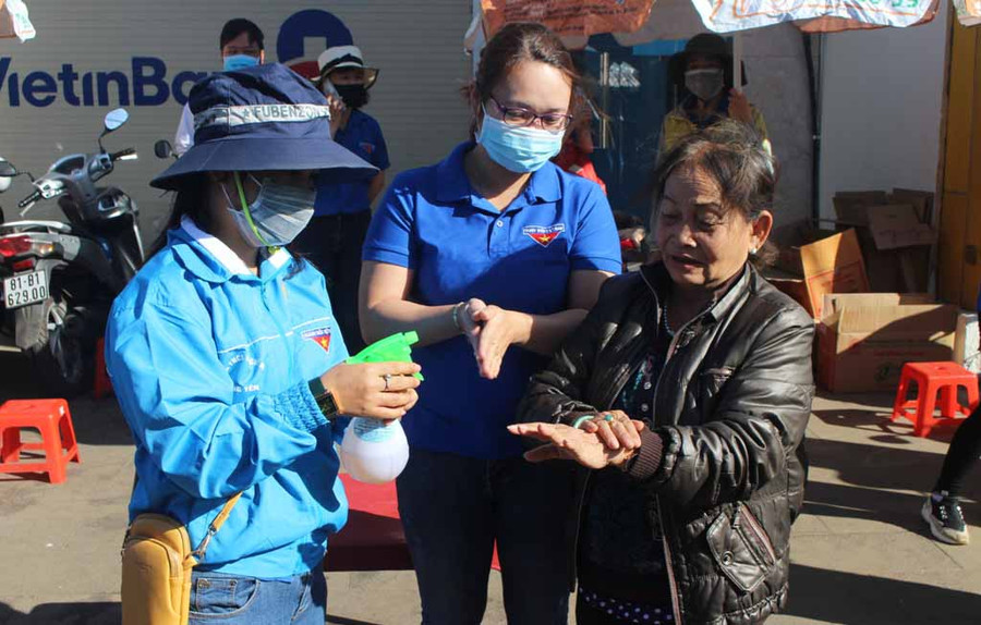 Đoàn viên, thanh niên phát nước rửa tay miễn phí cho người dân tại Trung tâm Thương mại Pleiku. Ảnh: Phan Lài
