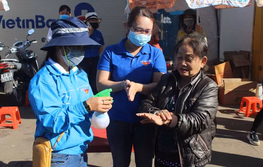 Đoàn viên, thanh niên phát nước rửa tay miễn phí cho người dân tại Trung tâm Thương mại Pleiku. Ảnh: Phan Lài