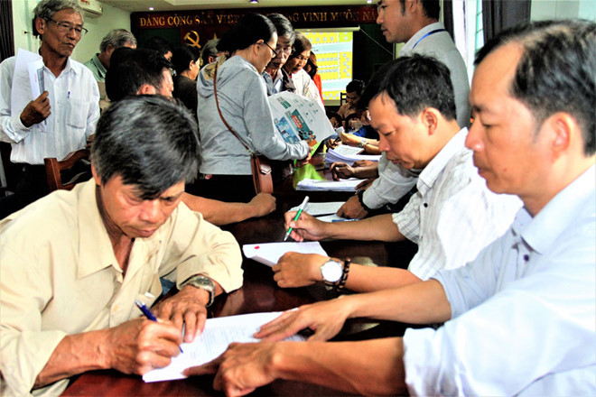 Người dân Thượng Thành làm thủ tục cấp “sổ đỏ” và giấy phép xây dựng nhà ngay sau khi bốc thăm chọn đất tái định cư - Ảnh: Đình Toàn