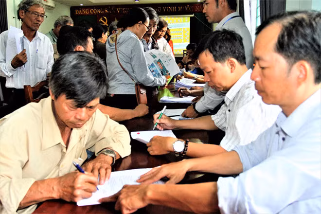 Người dân Thượng Thành làm thủ tục cấp “sổ đỏ” và giấy phép xây dựng nhà ngay sau khi bốc thăm chọn đất tái định cư - Ảnh: Đình Toàn