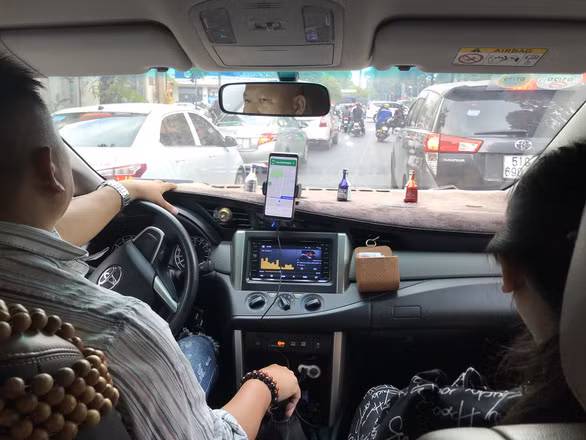  Theo Nghị định 10 của Chính phủ, người dân sẽ đánh giá dịch vụ xe công nghệ trên điện thoại di động đặt cuốc xe - Ảnh: QUANG ĐỊNH