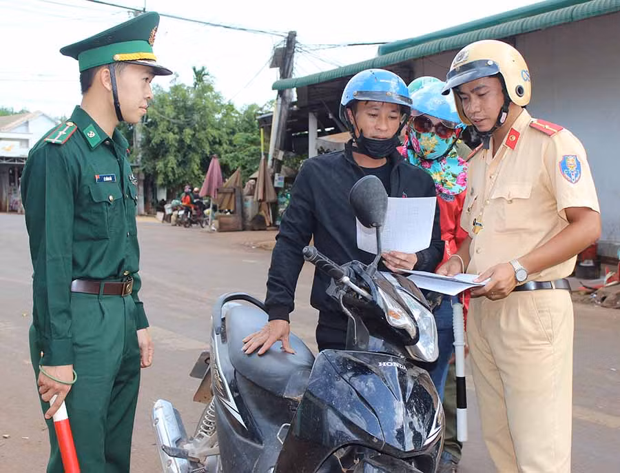  Cán bộ Đồn Biên phòng Ia Nan phối hợp cùng lực lượng Cảnh sát Giao thông tuyên truyền người dân chấp hành nghiêm Luật giao thông đường bộ. Ảnh: P.D