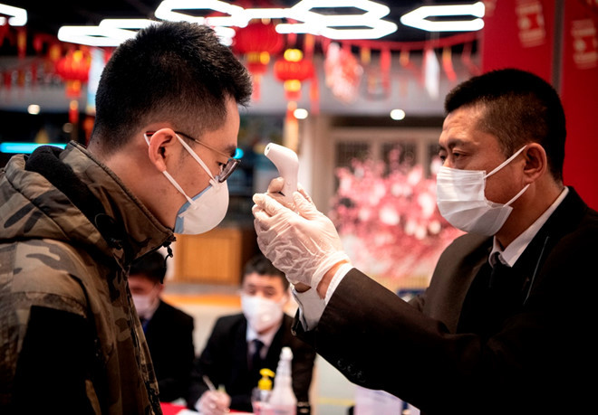 Nhân viên bảo vệ kiểm tra thân nhiệt khách hàng tại một siêu thị ở thành phố Hàng Châu, Trung Quốc ngày 5.2 - Ảnh: AFP Nhân viên bảo vệ kiểm tra thân nhiệt khách hàng tại một siêu thị ở thành phố Hàng Châu, Trung Quốc ngày 5.2 - Ảnh: AFP