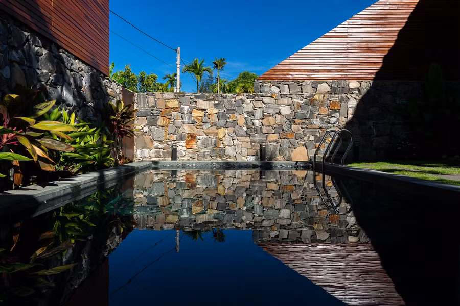  Hình dáng công trình giống một chiếc lều lớn, phản chiếu xuống hồ bơi khi mặt trời chiếu nghiêng.