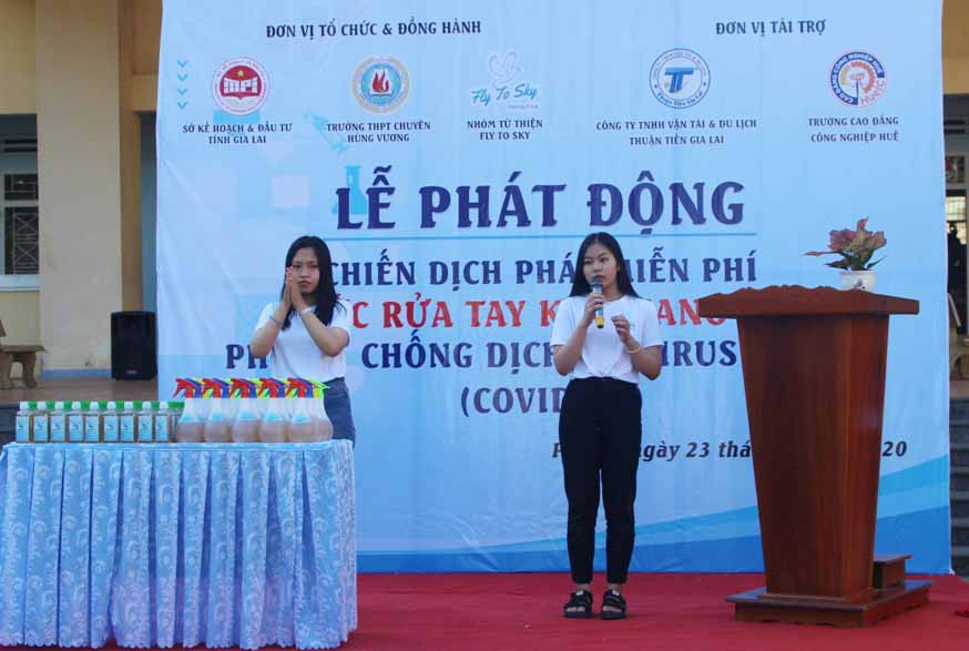 Thành viên nhóm tình nguyện Fly To Sky hướng dẫn quy trình sát khuẩn tay bằng dung dịch có cồn theo hướng dẫn của Bộ Y tế tại lễ phát động. Ảnh Phan Lài