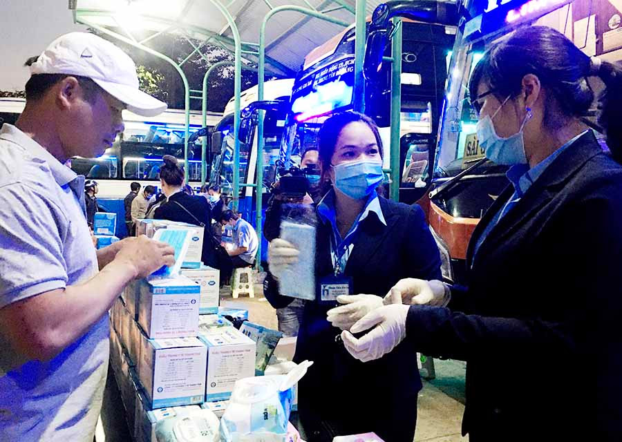  Nhân viên của nhà xe Thuận Tiến Gia Lai phát khẩu trang, khăn ướt tẩm cồn 70 độ cho hành khách tại Bến xe Đức long Gia Lai. Ảnh: L.H
