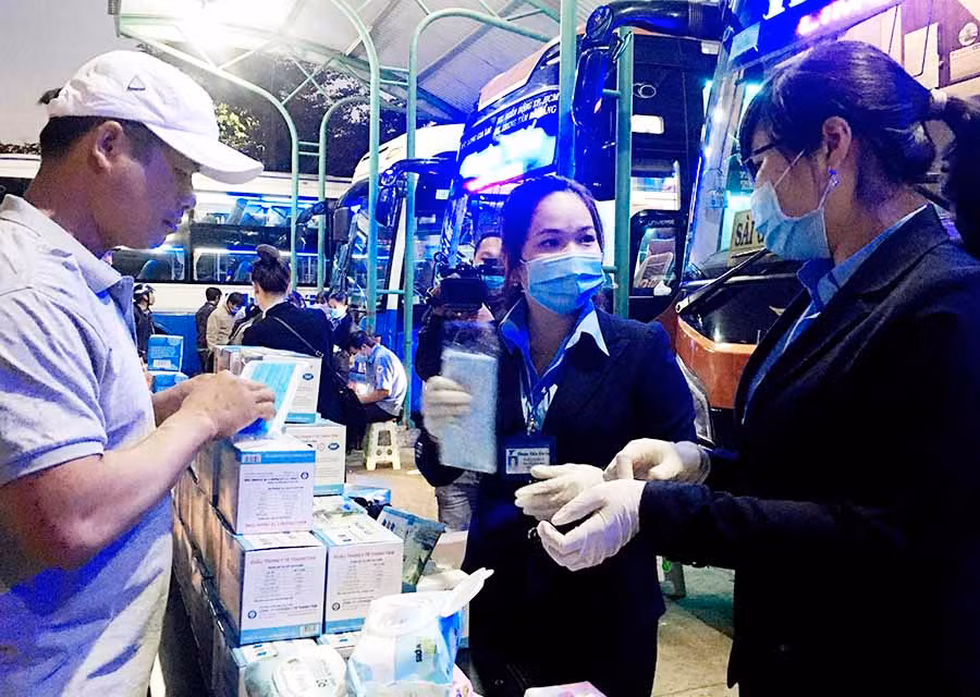  Nhân viên của nhà xe Thuận Tiến Gia Lai phát khẩu trang, khăn ướt tẩm cồn 70 độ cho hành khách tại Bến xe Đức long Gia Lai. Ảnh: L.H