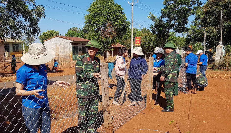  Cán bộ, công nhân viên của Công ty giúp người dân làm hàng rào. Ảnh: Vĩnh Hoàng