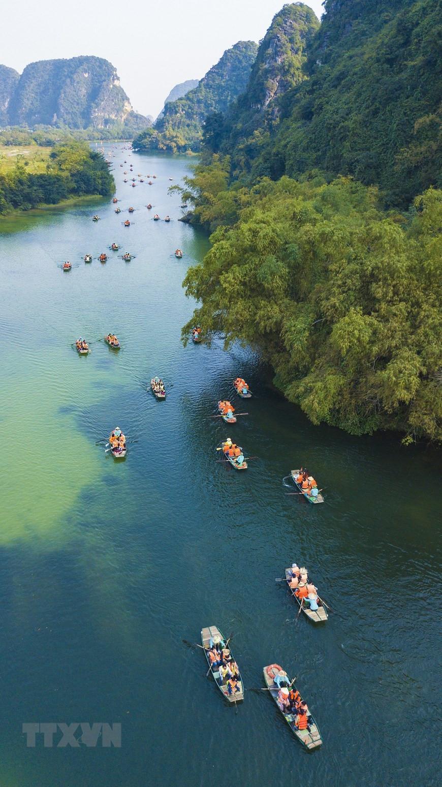  Một trong những trải nghiệm thú vị dành cho du khách khi đến Tràng An chính là ngồi thuyền xuôi dọc theo dòng sông nhìn ngắm cảnh vật xung quanh. (Ảnh: Minh Đức/TTXVN)