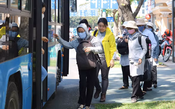 Hành khách đón xe buýt trên đường Đinh Tiên Hoàng, Q.1, TP.HCM - Ảnh: NGỌC PHƯỢNG