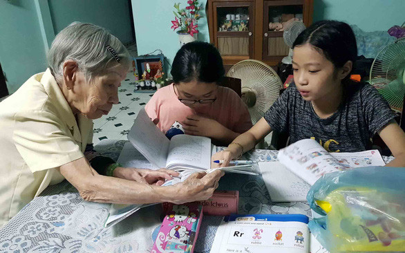 Cô giáo Trần Thị Bê với lớp dạy ngoại ngữ cho học sinh nghèo ở Huế - Ảnh: NHẬT LINH