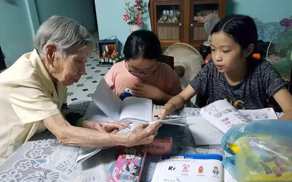 Cô giáo Trần Thị Bê với lớp dạy ngoại ngữ cho học sinh nghèo ở Huế - Ảnh: NHẬT LINH