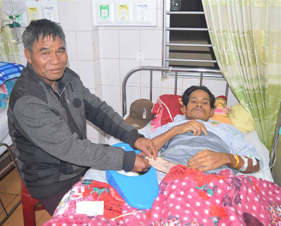 Ông Puih Tir chăm sóc anh Puih Hum tại bệnh viện. Ảnh: Đ.Y  Ông Puih Tir chăm sóc anh Puih Hum tại bệnh viện. Ảnh: Đ.Y