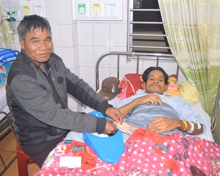  Ông Puih Tir chăm sóc anh Puih Hum tại bệnh viện. Ảnh: Đ.Y