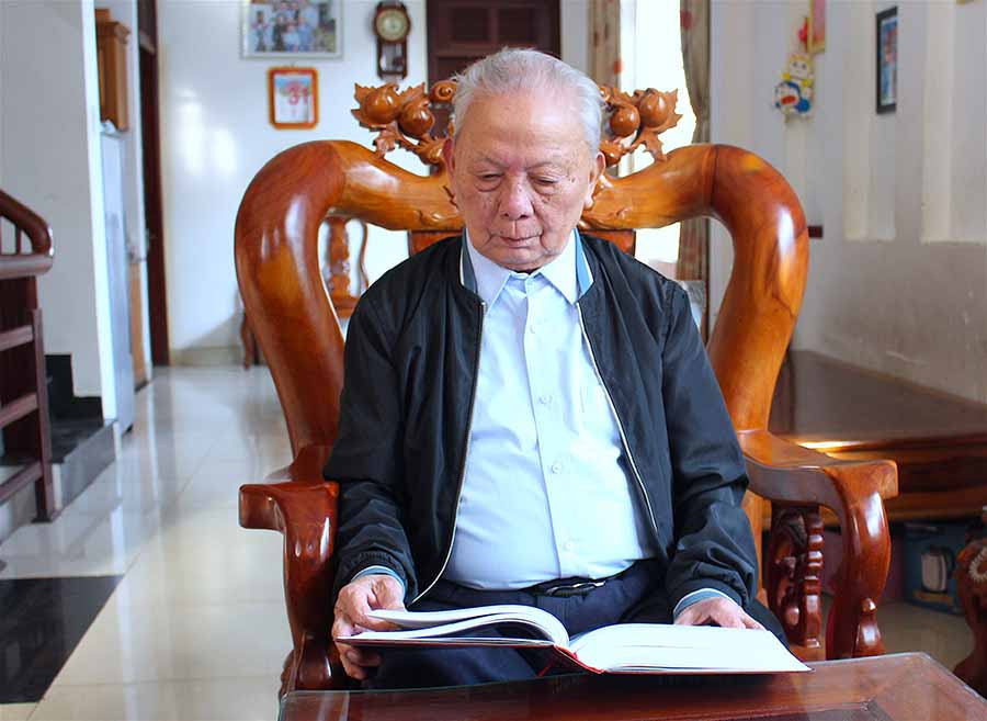 Ông Phan Anh Tuấn chậm rãi đọc lại từng trang Lịch sử Đảng bộ tỉnh Gia Lai (1945-2005). Ảnh: Mộc Trà