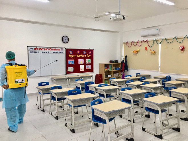 Nhiều trường chủ động phun khử trùng phòng học trong thời gian học sinh nghỉ - ẢNH: TRẦN CHÁNH