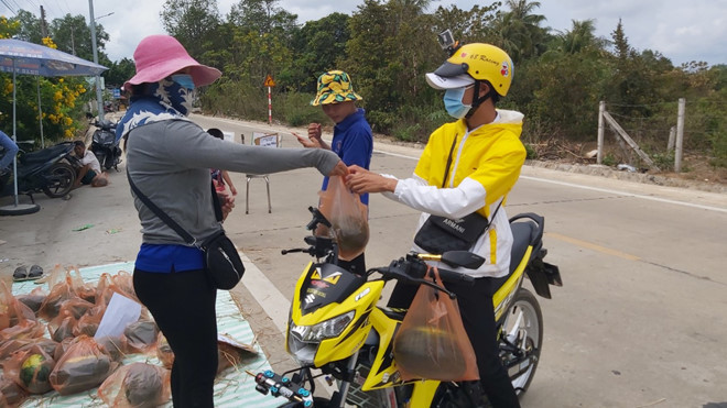 Chị Trang tặng dưa cho người dân - ẢNH: HOÀNG TRUNG