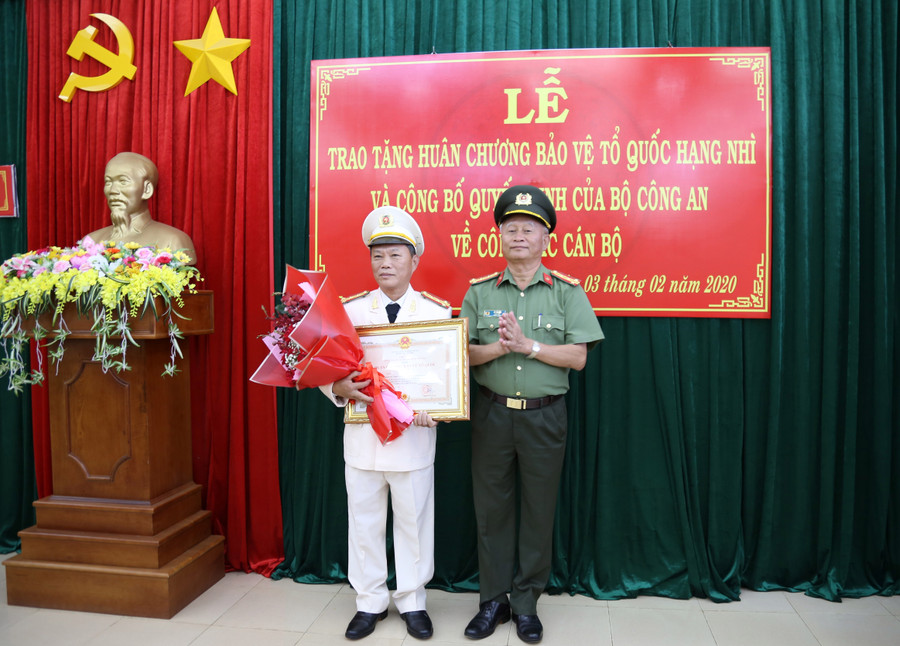  Đại tá Vũ Văn Lâu - Ủy viên BTV Tỉnh ủy, Bí thư Đảng ủy, Giám đốc Công an tỉnh trao Huân chương Bảo vệ Tổ quốc hạng nhì cho Đại tá Phan Lang - Nguyên Phó Bí thư Đảng ủy, nguyên Phó Giám đốc Công an tỉnh. Ảnh: Lê Ánh