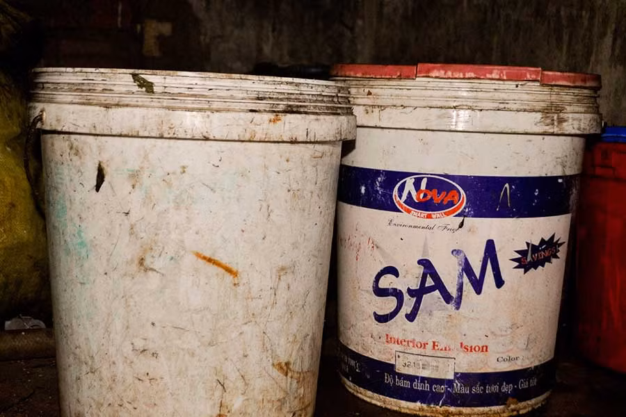Vỏ thùng sơn dùng để muối dưa cải đã cũ, cáu bẩn và bám những mảng màu vàng đục. Ảnh: Trần Dung