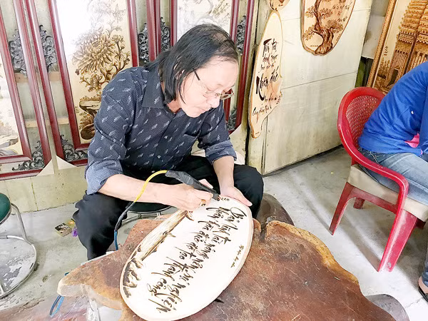  Nghệ sĩ Dzũ Kha viết thơ Hàn Mặc Tử trên phiến gỗ