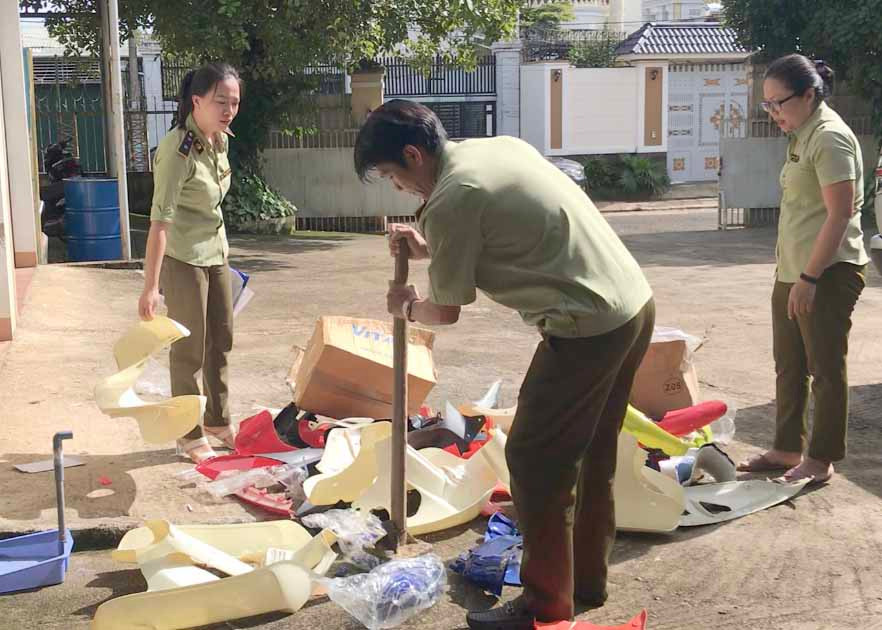 Dùng búa đập vỡ, làm biến dạng, cán vỡ vụng để tiêu huỷ hàng hoá vi phạm tại sân của Cục Quản lý thị trường Gia Lai. Ảnh: Vũ Thảo