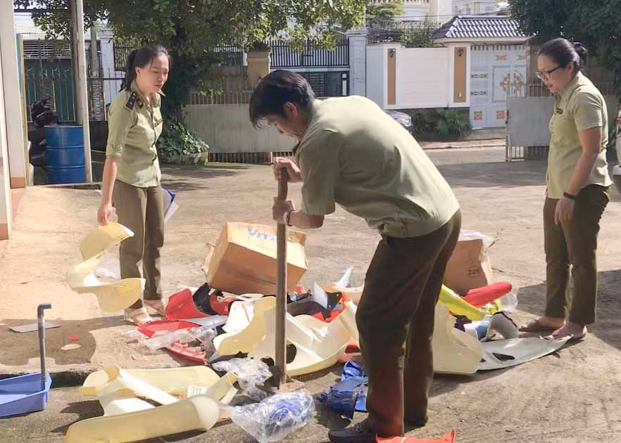 Dùng búa đập vỡ, làm biến dạng, cán vỡ vụng để tiêu huỷ hàng hoá vi phạm tại sân của Cục Quản lý thị trường Gia Lai. Ảnh: Vũ Thảo