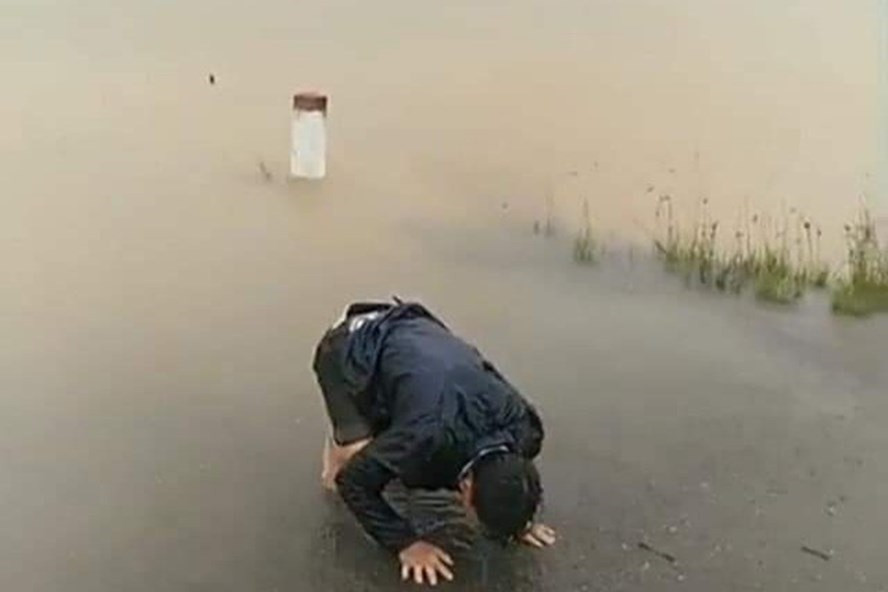 Người chồng ngã quỵ bên biển nước mênh mông - cảnh tượng thương tâm xảy ra ở huyện Phong Điền - Thừa Thiên-Huế trong cơn bão lũ vừa qua. Ảnh: Cắt từ clip.