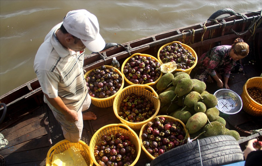 Người dân bán các loại trái cây cho du khách khi đến tham quan tại chợ nổi Cái Răng.