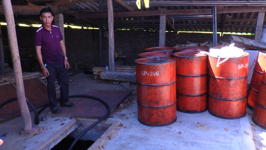  Ông Lê Tấn Hùng bên các thùng phuy dầu giả.