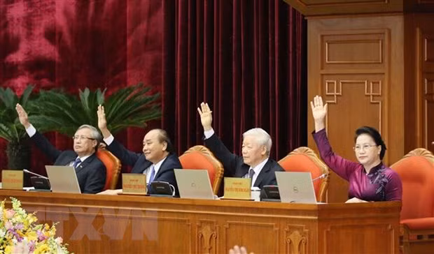 Các đồng chí lãnh đạo Đảng, Nhà nước biểu quyết thông qua Nghị quyết Hội nghị. (Ảnh: Phương Hoa/TTXVN)