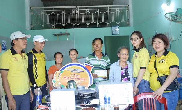 Các thành viên quỹ xe trao tặng “Nhà Cam” cho gia đình chị Thủy - Ảnh: ĐOÀN NHẠN