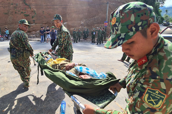 Lực lượng quân đội đưa các nạn nhân trong vụ sạt lở đất ở Trà Leng ra khỏi hiện trường để đi cứu chữa - Ảnh: NGỌC HIỂN