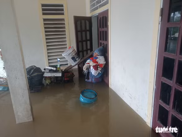 Cụ già, trẻ nhỏ được đưa lên tầng hai tránh lũ - Ảnh: VĂN ĐỊNH